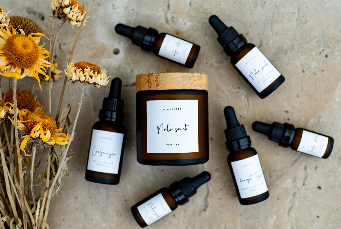 Professional flat lay product photography of artisanal skincare bottles on a stone surface with dried flowers